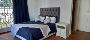 DeneysvilleHome Sweet Home的一间卧室配有一张带蓝色棉被的床和窗户。