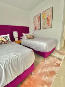 La MairenaLa Cala Golf - Luxury 3bed apartment - First line golf view的紫白色客房的两张床