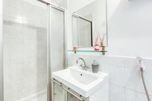 库尔布瓦T2 La Défense avec Parking privé的白色的浴室设有水槽和淋浴。