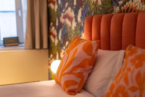 罗维尼The Melegran的一张带两个橙色和白色枕头的床