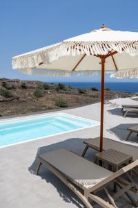 伊亚Alegria by Casa Sigalas的游泳池旁的白色遮阳伞和椅子