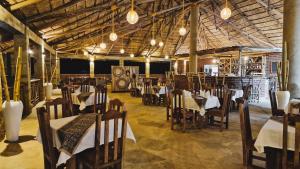 卡拉图Africa Safari Karatu的一间在房间内配有桌椅的餐厅
