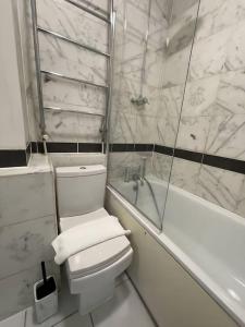 伦敦Beautiful haven,Tower Bridge Rd的白色的浴室设有卫生间和浴缸。