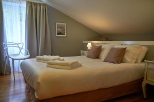 普拉亚达维多利亚Materramenta的卧室配有带毛巾的大型白色床