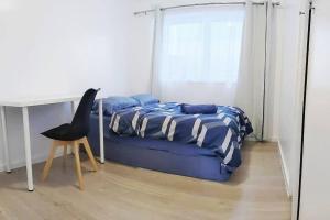 墨尔本PROMO 2-Bedroom Villa Next to Train Station, FREE PARKING的一间卧室配有一张床、一张桌子和一把椅子