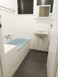 墨尔本PROMO 2-Bedroom Villa Next to Train Station, FREE PARKING的白色的浴室设有水槽和浴缸。