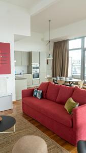 安特卫普Smartflats - Central Antwerp的一间带红色沙发的客厅和一间厨房
