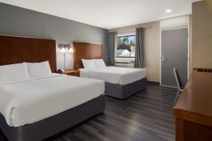 坎卢普斯Canadas Best Value Inn & Suites Kamloops的酒店客房设有两张床和电视。