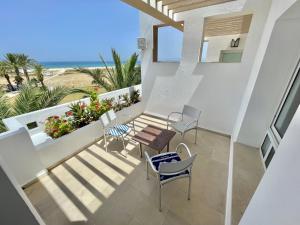 比塞大Beachfront Apartment - Andalucia的一个带桌椅的阳台和海滩