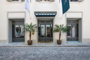 佛罗伦萨Hotel La Gemma的两棵棕榈树,在一座建筑前