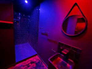Plan dʼAupsLe Maquis Rooms的浴室设有水槽和带紫色灯的镜子