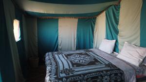 姆哈米德Camp Desert Trips的一间卧室配有一张带天蓬的床