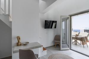 伊亚Alegria by Casa Sigalas的白色的客厅配有桌子和电视。