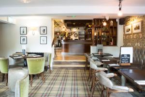 塔博雷Alvanley Arms, Cotebrook的一间带桌椅的餐厅和一间酒吧