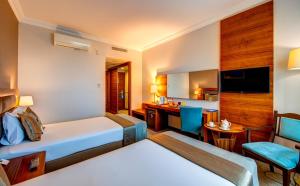 科尼亚科尼亚贝拉酒店的配有一张床和一张书桌的酒店客房