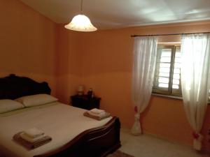 圣欧费米亚拉默齐亚VILLA CORTESE的一间卧室设有一张床和一个窗口