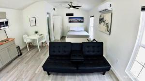 布兰登All modern Studio with private entry & parking.的一间带黑色沙发的客厅和一间卧室