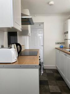 吉林汉姆Home in Medway的厨房配有白色橱柜和台面