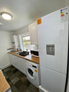 吉林汉姆Home in Medway的厨房配有白色冰箱和洗衣机。