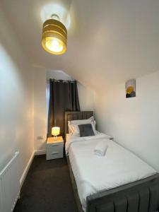 吉林汉姆Home in Medway的一间小卧室,配有床和灯