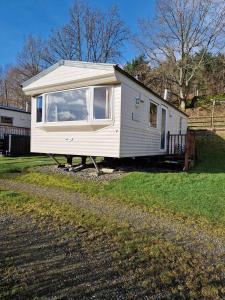 基林Cruachan Caravan and Camping Farm的院子里的白色小房子