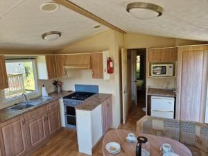 基林Cruachan Caravan and Camping Farm的厨房配有水槽和炉灶 顶部烤箱