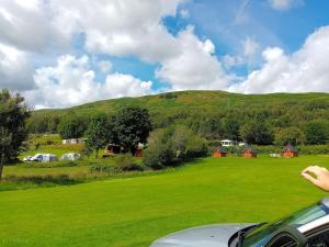 基林Cruachan Caravan and Camping Farm的绿色的田野,山丘背景