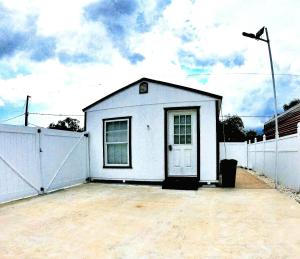 布兰登All modern Studio with private entry & parking.的白色的小房子,有白色的围栏