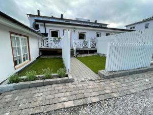 奇维克Enkelheten i Kivik的白色的房子,有栅栏和院子