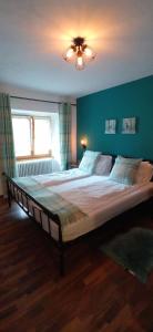 Radmer an der HaselGasthof Zum Lugauer的卧室内的一张大床,卧室内有蓝色的墙壁