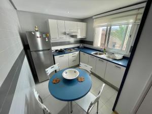 比塞大Beachfront Apartment 105- Hotel Andalucia的小厨房配有蓝色桌子和冰箱