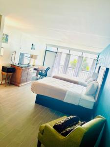 默特尔比奇Summer Wind Ocean Front Hotel的一间卧室配有一张大床、一张桌子和一把椅子