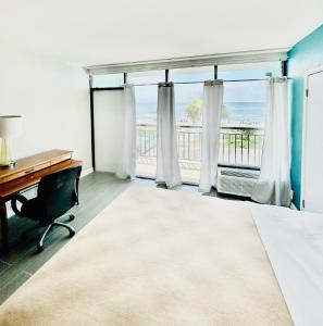 默特尔比奇Summer Wind Ocean Front Hotel的一间卧室配有一张桌子和一个享有海景的窗户。