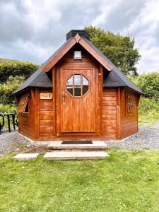 基林Cruachan Caravan and Camping Farm的一间小木小屋,在草地上有一扇门