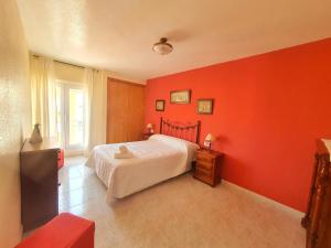 阿桂拉斯Vistas al mar con Aire Acondicionado y Parking - by Aloha Palma的一间拥有红色墙壁的卧室和一张位于客房内的床