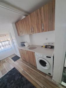 普里兹伦Arel's Home的小厨房配有洗衣机和木制橱柜。