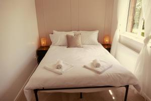 WarmleyHome in Longwell Green的一间卧室配有一张床,上面有两条毛巾