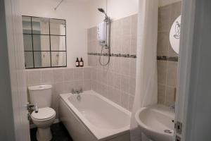 WarmleyHome in Longwell Green的浴室配有卫生间、浴缸和水槽。