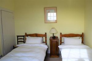 盖特豪斯厄夫弗利特Rowantree Cottage的卧室配有两张床,墙上挂着一幅画