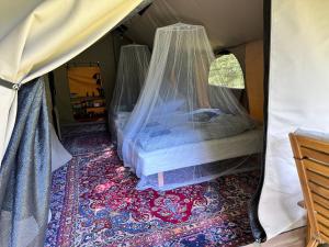 纳克斯考Langø Feriecenter - Outdoor Lodge的帐篷内的一张床位,配有蚊帐