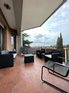 罗马Eur Centro lux apartment con camino的阳台的天井配有沙发和椅子