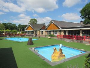 福尔特赫伊曾HderH - Eco Lodge op vakantiepark De IJsvogel, zwembaden, kids fun, natuur en rust的大楼前的大型游泳池