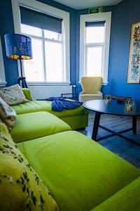 韦斯特曼纳埃亚尔Guesthouse Holl的客厅配有两张绿色沙发和一张桌子