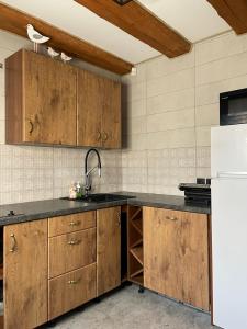 托伊拉Toila Pikk Apartment的厨房配有木制橱柜和白色冰箱。