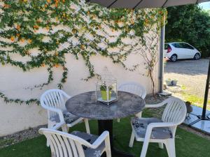 Saint-Sylvestre-sur-LotLe Coq en Repos的伞下一张桌子和四把椅子