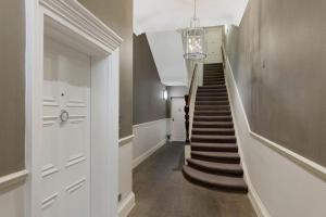 伦敦Wonderful Knightsbridge Apartment by Harrods的走廊上设有吊灯的楼梯