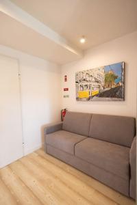 里斯本Superb Central Lisbon Apartment的客厅配有沙发和墙上的绘画