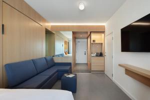蒙特利尔ITHQ酒店的一间带蓝色沙发的客厅和一间卧室