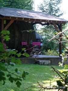 Lisoresles tonneaux de Lisores的木制凉亭,配有2把粉红色的椅子