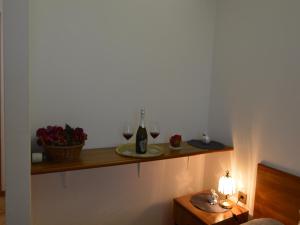 KaštelBassanese Kastel的一间房间,配有带两杯葡萄酒的架子